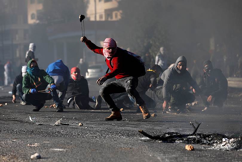 Рамалла, Западный берег реки Иордан. Один из протестующих палестинцев закидывает солдат и полицию камнями