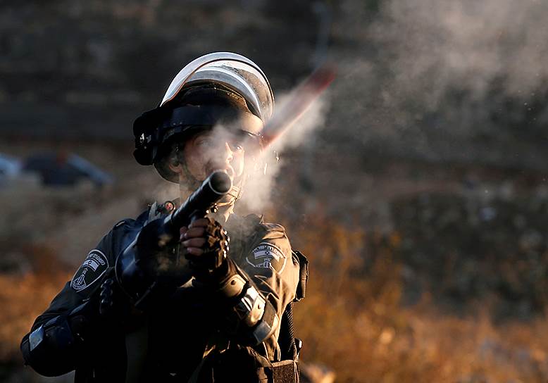 Рамалла, Западный берег реки Иордан. Израильский полицейский стреляет по протестующим палестинцам во время беспорядков после признания президентом США Дональдом Трампом Иерусалима столицей Израиля 