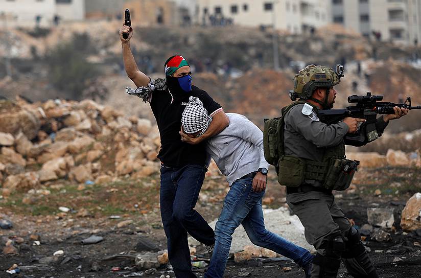 Бейт-Эль, Западный берег реки Иордан. Израильский военный задерживает палестинского протестующего во время столкновений 