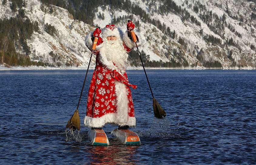 Красноярск, Россия. Местный житель в костюме Деда Мороза плывет по реке Енисей