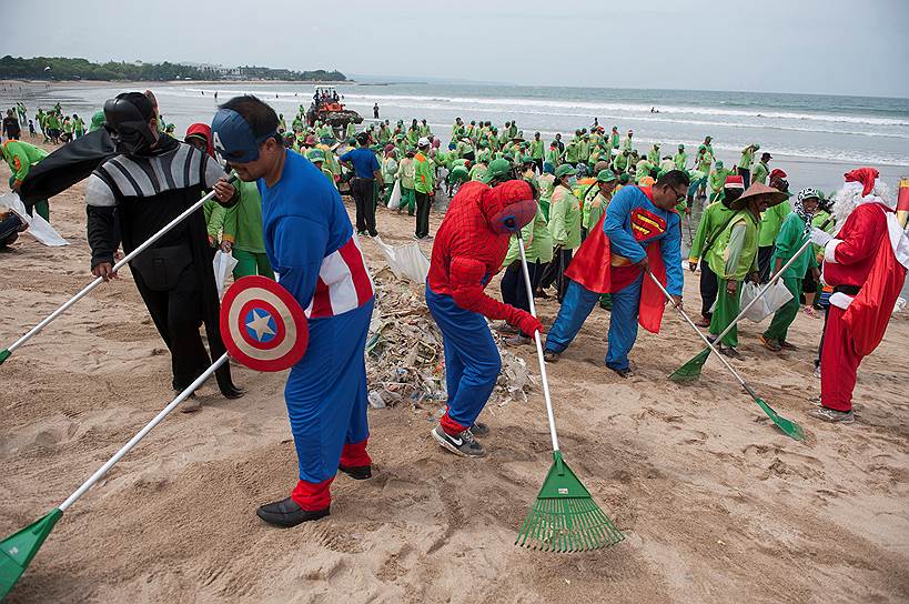 Бали, Индонезия. Рабочие в костюмах супергероев убирают мусор на пляже Кута