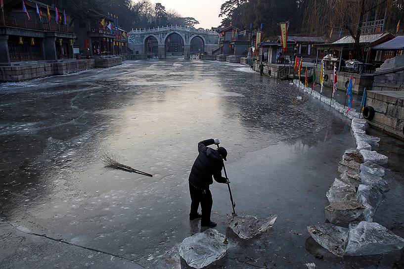 Пекин, Китай. Рабочий убирает лед в водоеме на территории садово-дворцового комплекса Юаньминъюань 
