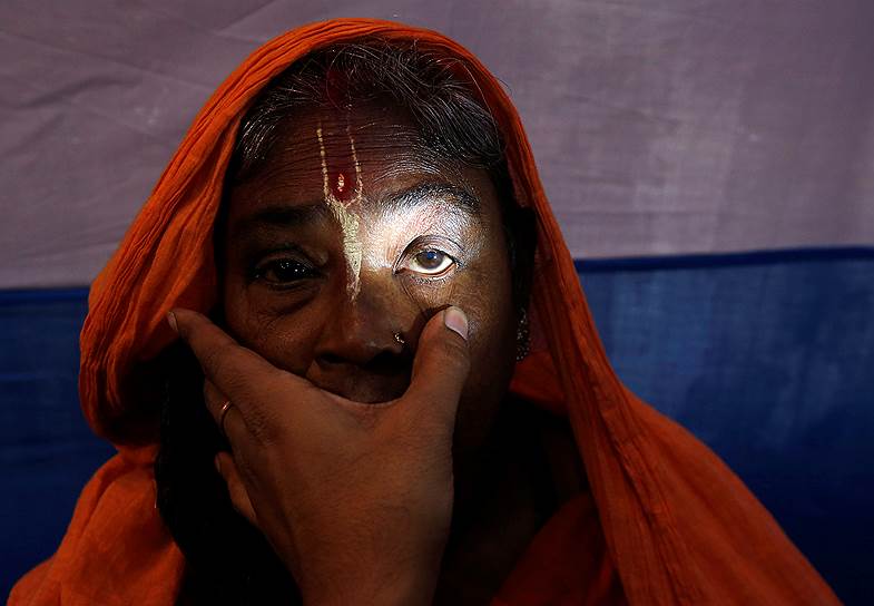 Калькутта, Индия. Индуистская верующая проверяет зрение перед отбытием на остров Сагар для участия в празднике Макара-санкранти 