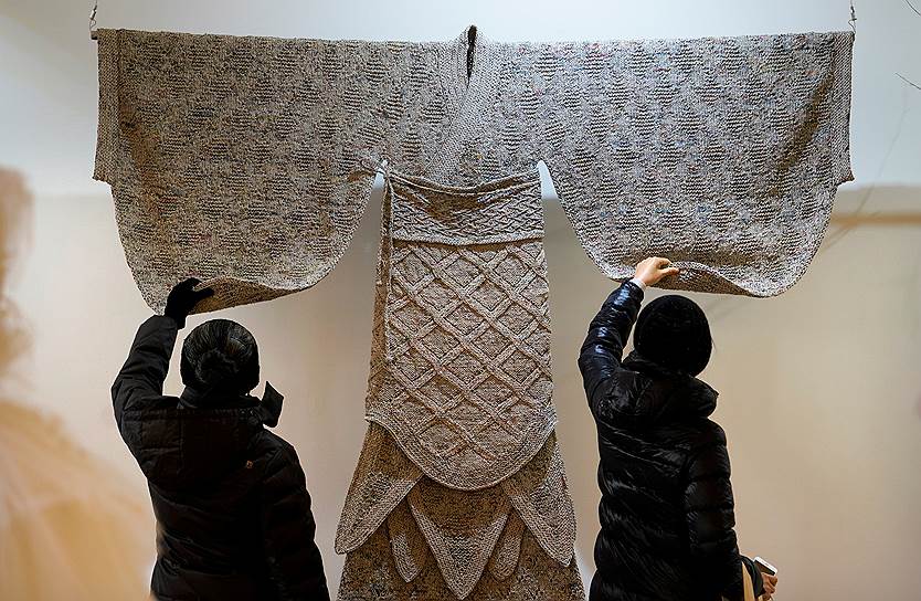 Пекин, Китай. Посетители выставки рассматривают одеяние времен династии Хань, воссозданное из старых газет дизайнером Ванг Леем
