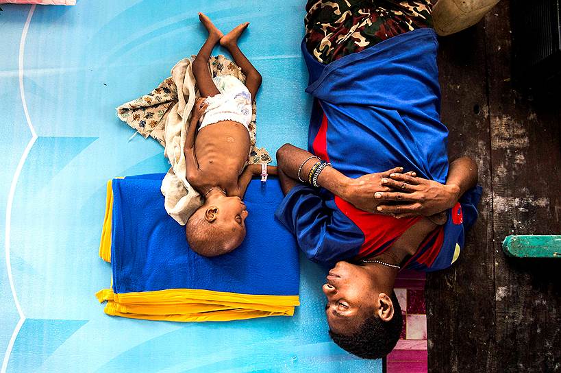 Агата, Папуа—Новая Гвинея. Мама с ребенком в протестантской церкви, куда был переведен медицинский персонал для борьбы с недоеданием и корью