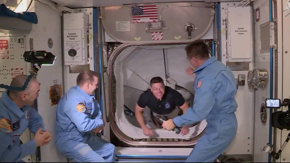 31 мая 2020 года к станции успешно пристыковался корабль Crew Dragon компании SpaceX. Это был первый после прекращения запусков шаттлов пилотируемый полет, осуществляемый с территории США на американском космическом корабле&lt;br>
На фото: астронавт Роберт Бенкен (в центре) прибыл на МКС 