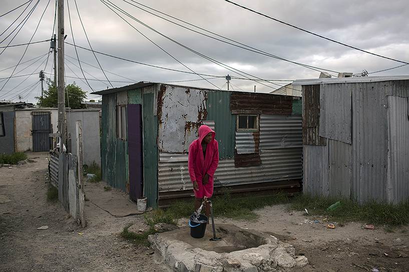 Кейптаун, ЮАР. Местная жительница набирает воду