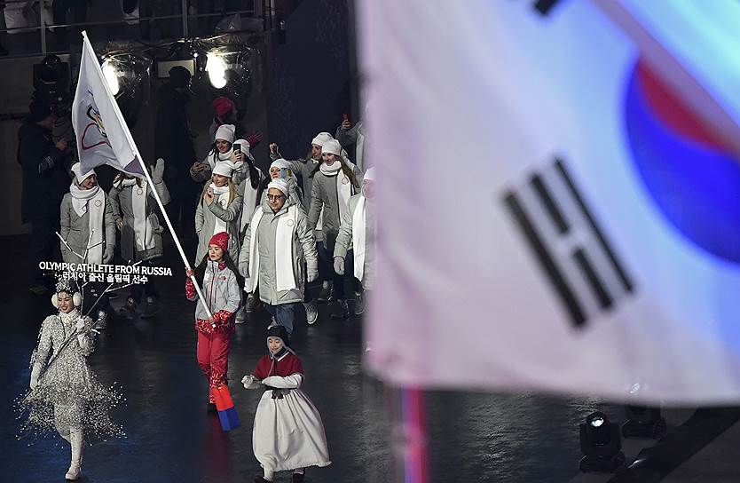 Команда россиян вышла под олимпийским флагом, который нес волонтер. После допингового скандала МОК допустил к участию 168 спортсменов