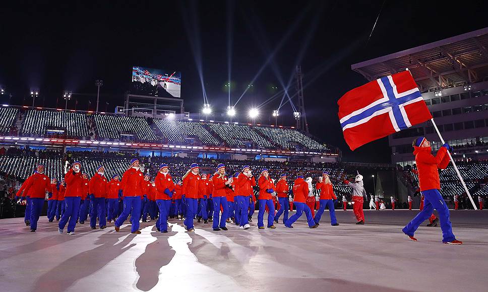 Биатлонист Эмиль Хегле Свендсен несет флаг Норвегии на церемонии открытия Олимпиады

