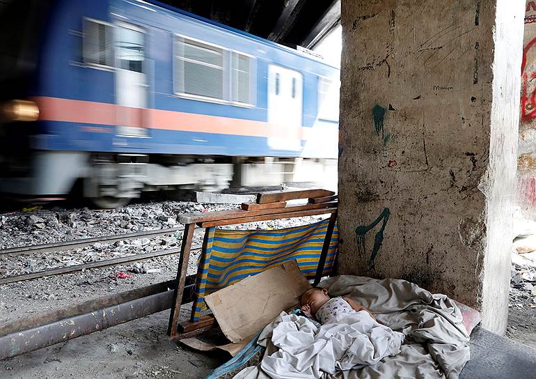 Санта Меса, Филиппины. Бездомный ребенок спит рядом с железнодорожными путями