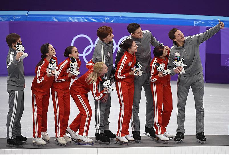 Олимпийские спортсмены из России, завоевавшие серебряные медали в командных соревнованиях по фигурному катанию, во время цветочной церемонии награждения

