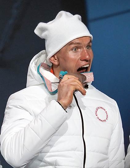 Завоевавший серебряную медаль российский лыжник Александр Большунов  во время церемонии награждения