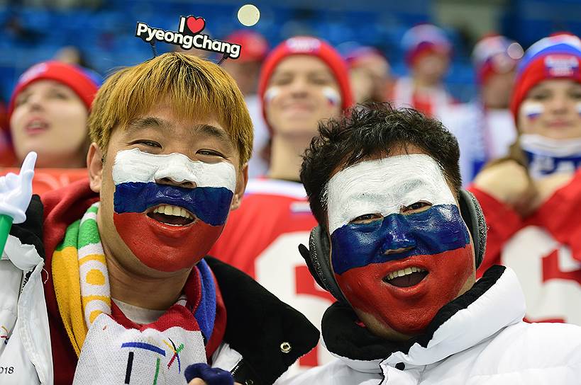 Пхёнчхан, Южная Корея. Болельщики из Азии с нарисованным на лице флагом России во время матча по хоккею между командами из России и Словакии 