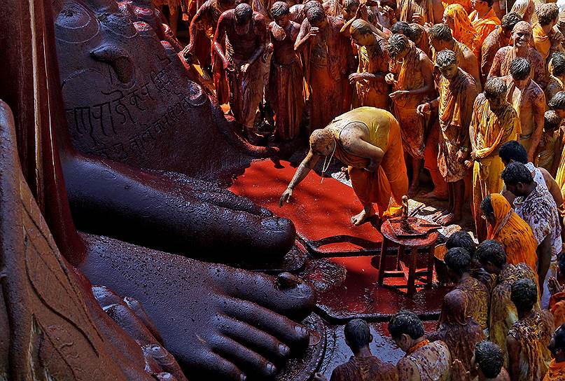 Шраванабелагола, Индия. Верующий трогает ступни статуи бога Гоматешвары