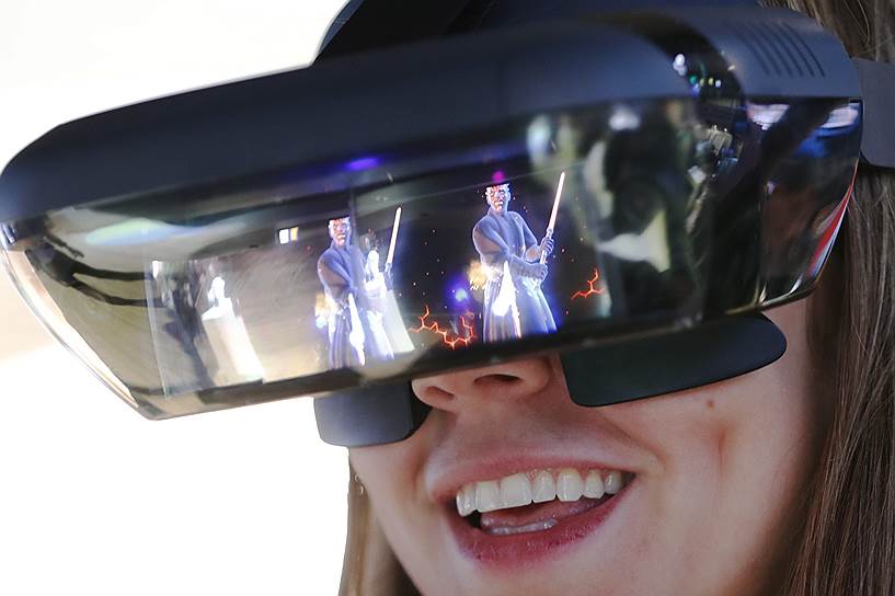 Посетительница тестирует очки дополненной реальности от компании Lenovo 