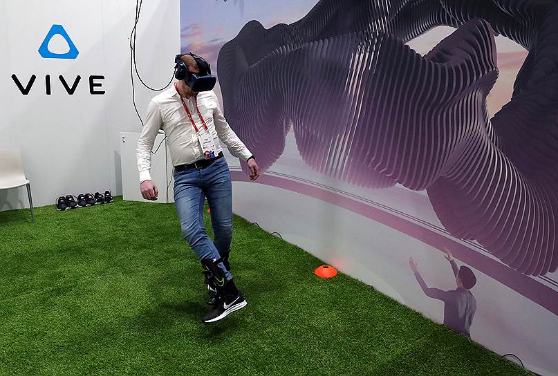 Посетитель играет в футбол, используя гарнитуру виртуальной реальности Vive 