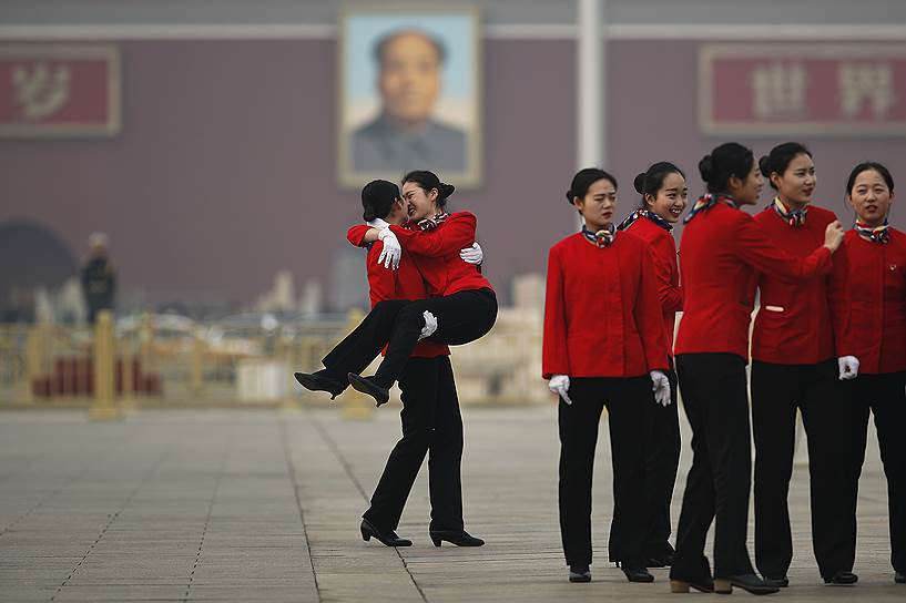 Пекин, Китай. Сотрудники сферы гостиничных услуг фотографируются на площади Тяньаньмэнь