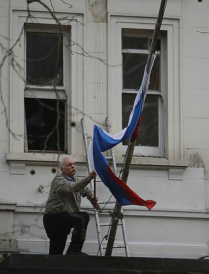 Лондон, Великобритания. Сотрудник российского посольства поправляет флаг
