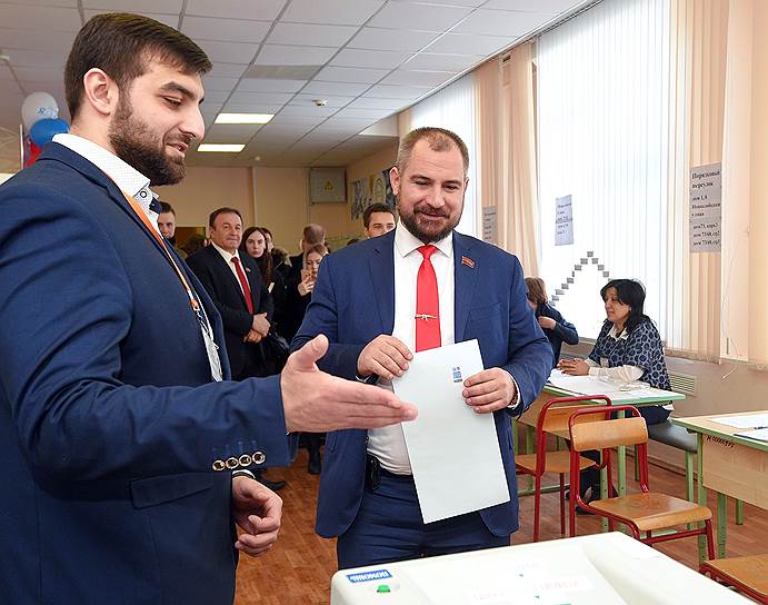 Кандидат на пост президента РФ от партии &quot;Коммунисты России&quot; Максим Сурайкин (справа) во время голосования на избирательном участке № 137