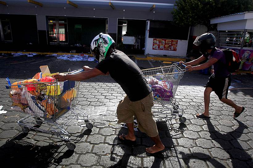 На фоне протестов активизировались вандалы и мародеры&lt;br>
На фото: мародеры убегают с тележками из супермаркета
