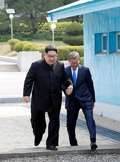 В ходе встречи Ким Чен Ын (слева) оказался на стороне Южной Кореи, переступив бетонную пограничную линию. Затем он неожиданно предложил перейти этот рубеж своему южнокорейскому коллеге. Взяв его за руку, Ким Чен Ын перевел Мун Джэ Ина (справа) на сторону КНДР