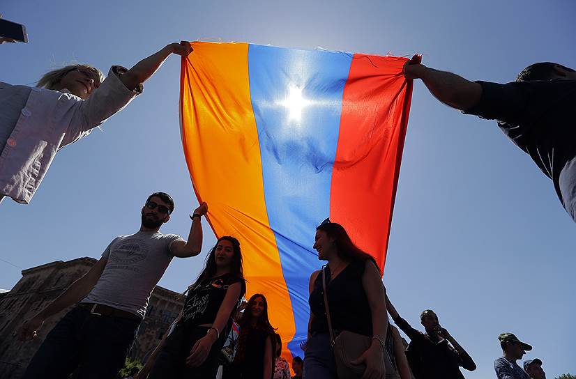 Протестующие несут в руках армянский флаг