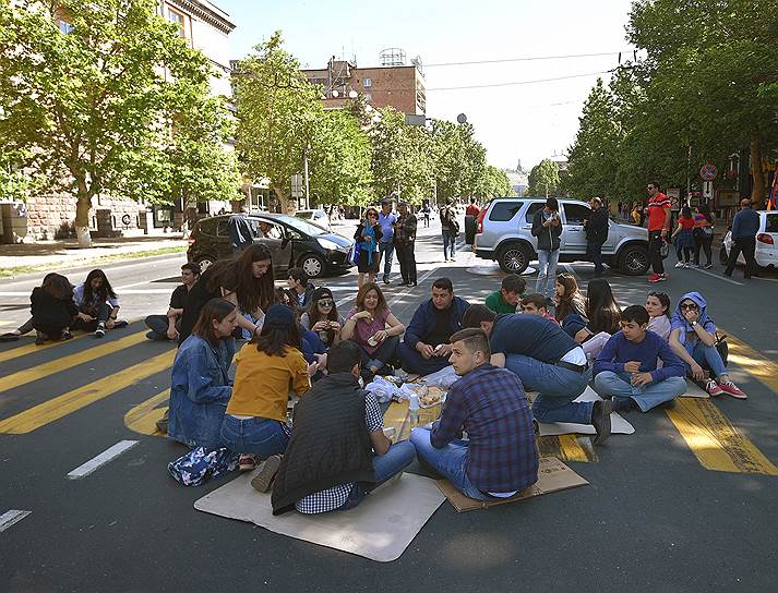 Протестующие сидят на проезжей части, блокируя дорогу