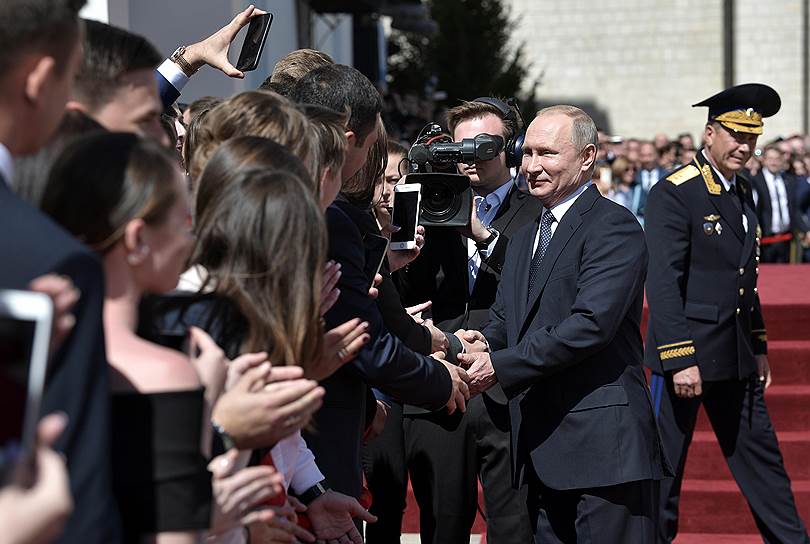 Избранный президент РФ Владимир Путин приветствует сторонников на Соборной площади
после церемонии инаугурации 