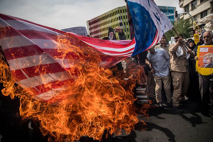 Тегеран, Иран. Местные жители сжигают американский флаг после решения президента США Дональда Трампа о выходе из ядерной сделки с Ираном и возобновлении санкций 