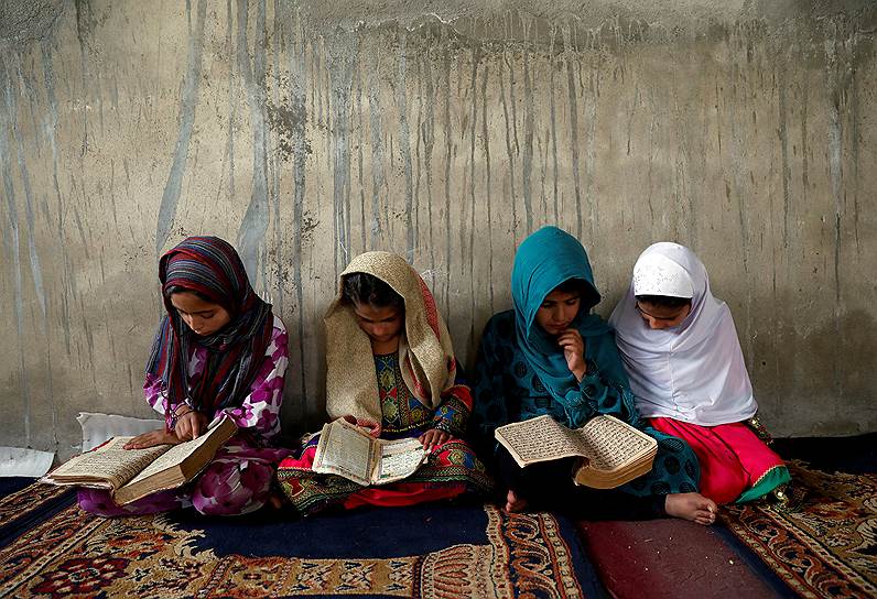 Кабул, Афганистан. Девушки читают Коран в медресе во время мусульманского священного месяца Рамадан
