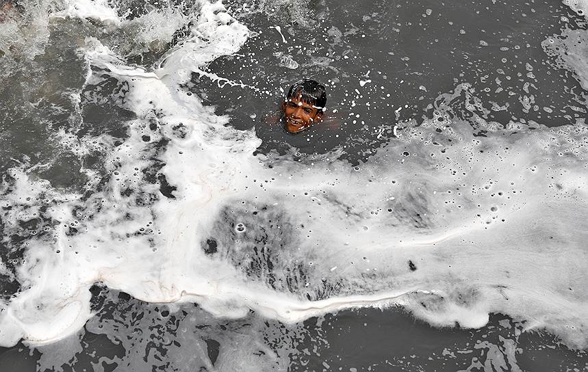 Нью-Дели, Индия. Мальчик плавает в загрязненной воде реки Ямуна