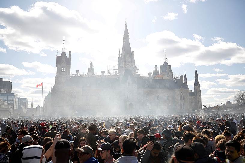 Оттава, Канада. Местные жители курят марихуану перед зданием парламента после принятия законопроекта о ее легализации