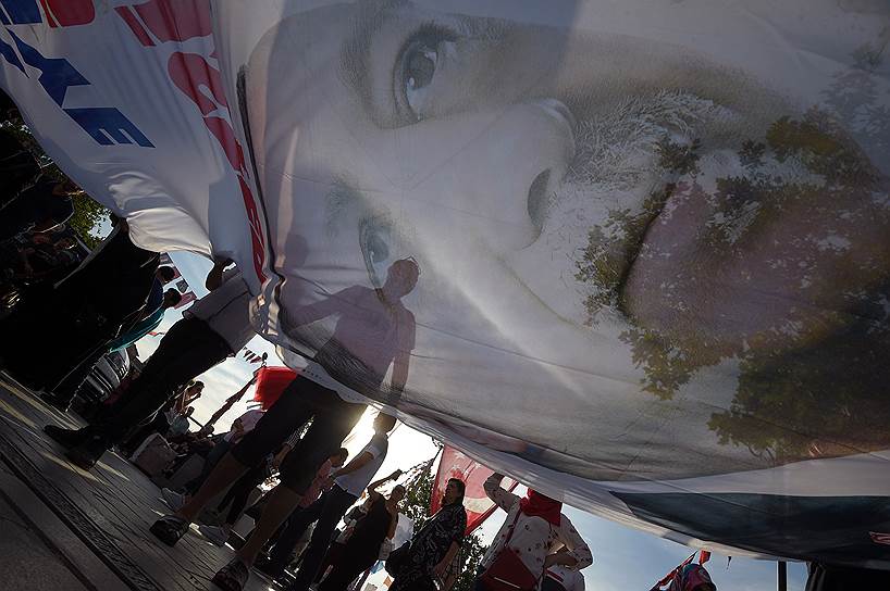 Стамбул, Турция. Люди несут агитационный плакат кандидата на пост президента, действующего президента Турции Реджепа Тайипа Эрдогана