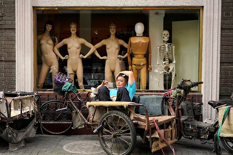 Шанхай, Китай. Местный житель перед магазином по продаже манекенов 