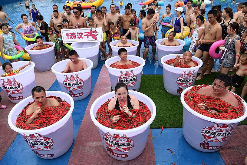 Чунцин, Китай. Участники конкурса, в ходе которого нужно продержаться пять минут в бочке с острыми перцами чили
