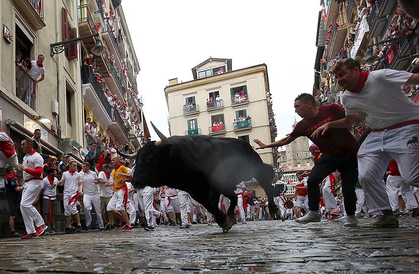 На фото: участники пытаются увернуться от быка в первый день забега