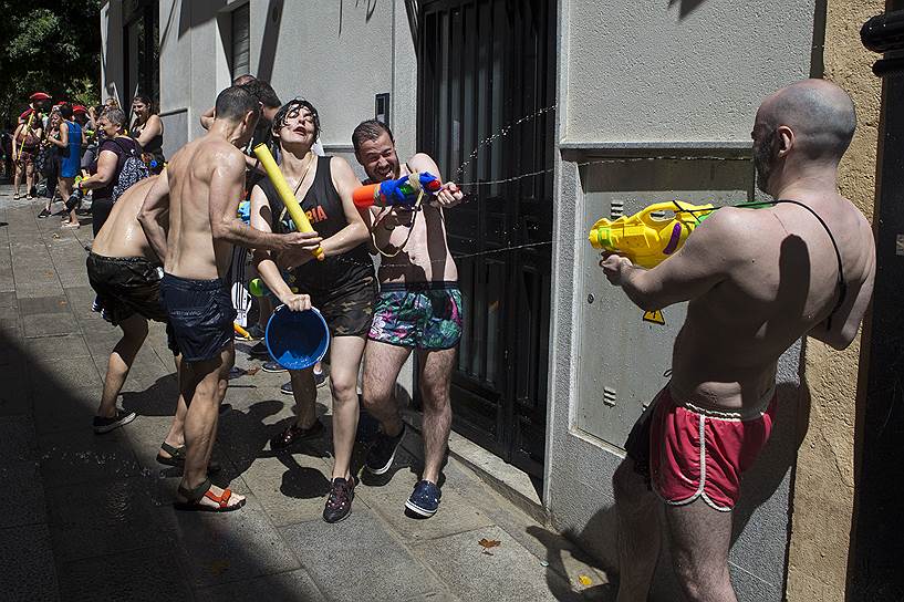 Мадрид, Испания. Жители стреляют друг в друга из водных пистолетов во время ежегодного дня водных сражений