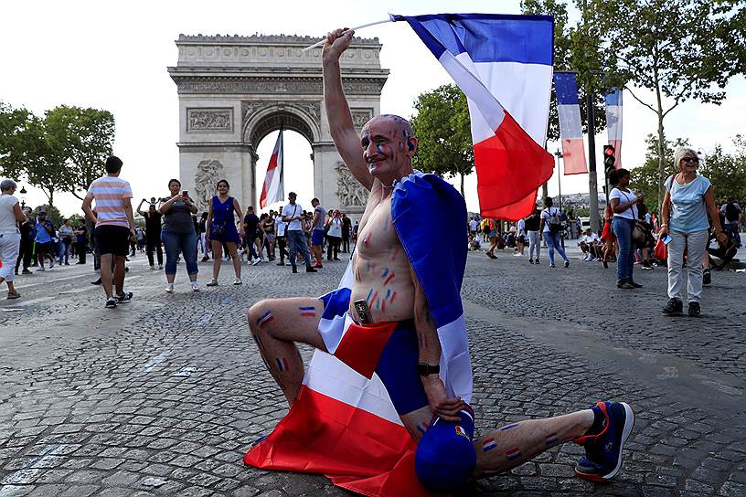 Болельщик на фоне Триумфальной арки на Елисейских полях в Париже