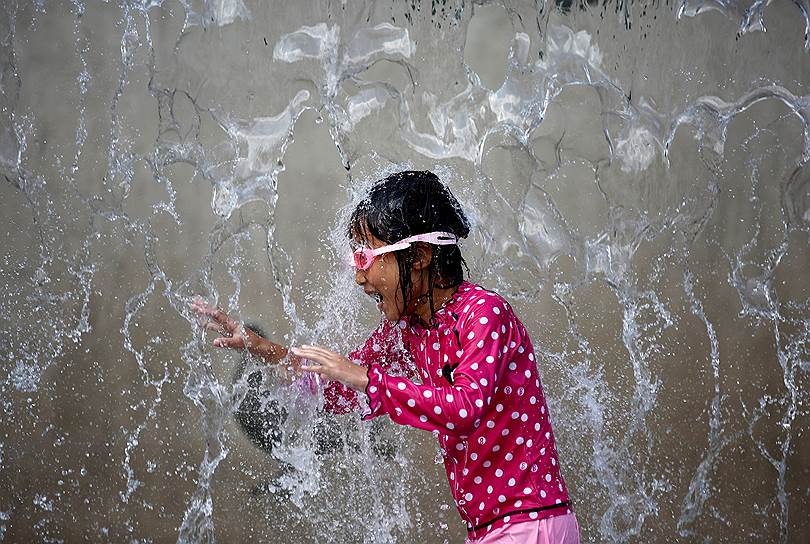 Токио, Япония. Девочка охлаждается в фонтане