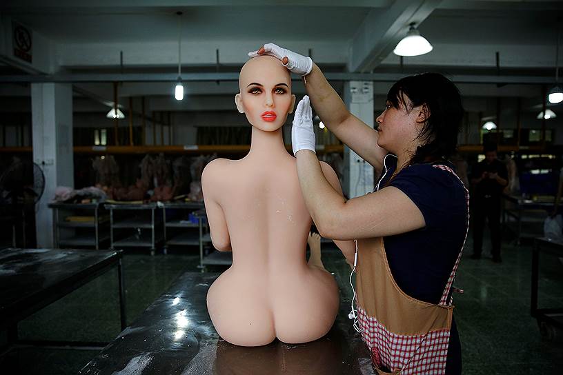 Чжуншань, Китай. Работница завода собирает секс-куклу

