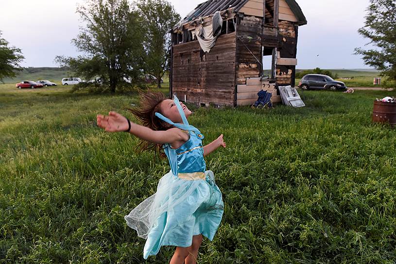 Грин Грасс, Южная Дакота (США). Девочка играет рядом с заброшенным домом