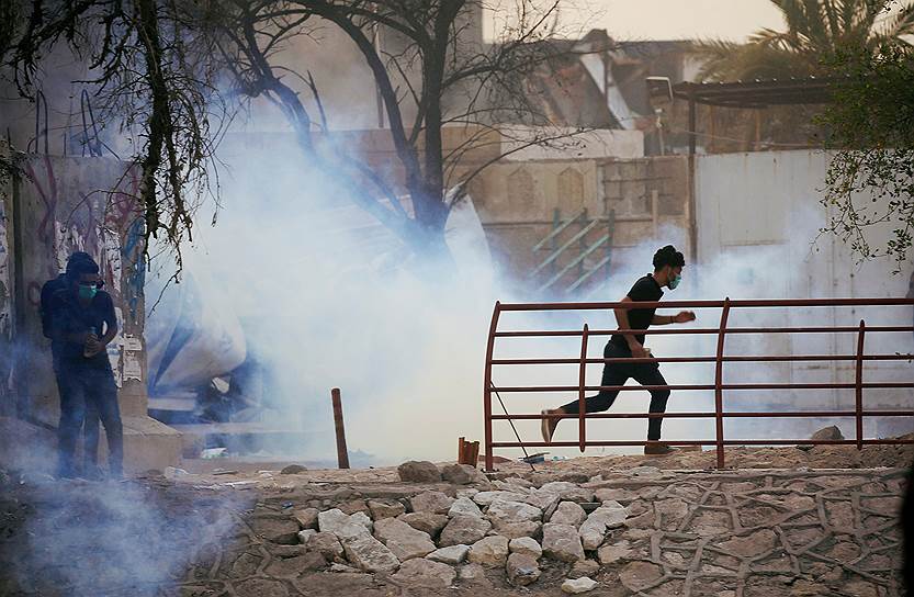 Басра, Ирак. Протестующие спасаются от слезоточивого газа, распыленного около здания правительства