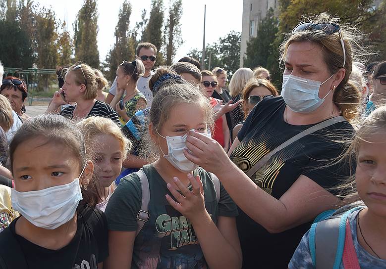 Учительница школы №3 города Армянска помогает правильно надеть маску одной из школьниц