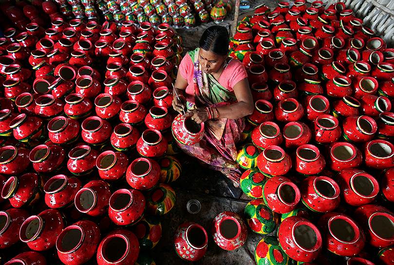 Ахмедабад, Индия. Местная жительница раскрашивает глиняные кувшины