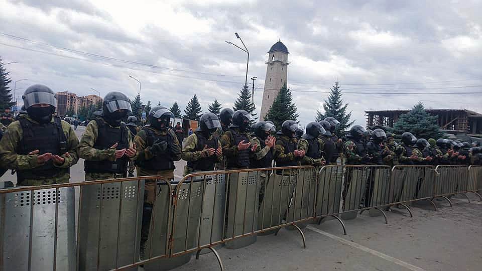 Сотрудники полиции молятся во время митинга в столице Ингушетии