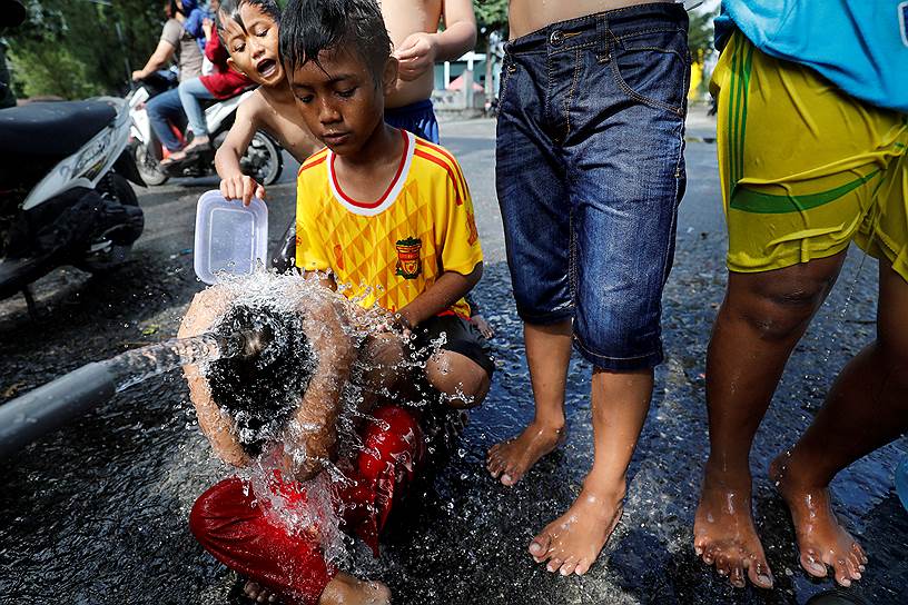 Палу, Индонезия. Дети купаются в лагере для пострадавших после землетрясения и цунами