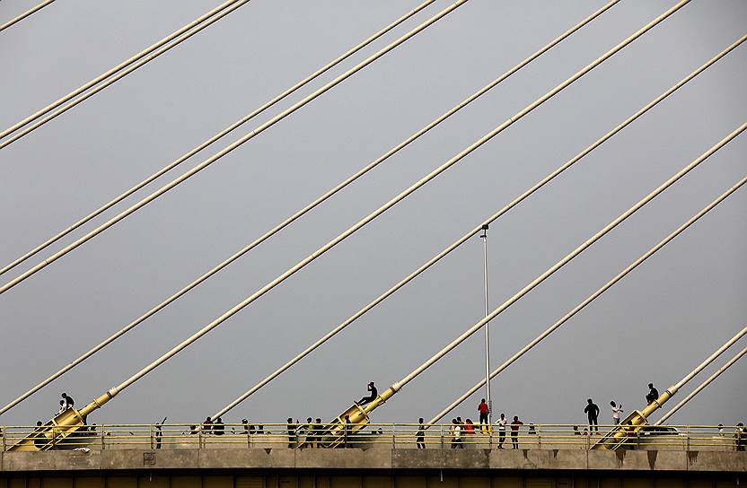 Нью-Дели, Индия. Люди стоят на недавно открывшемся мосту через реку Джамна
