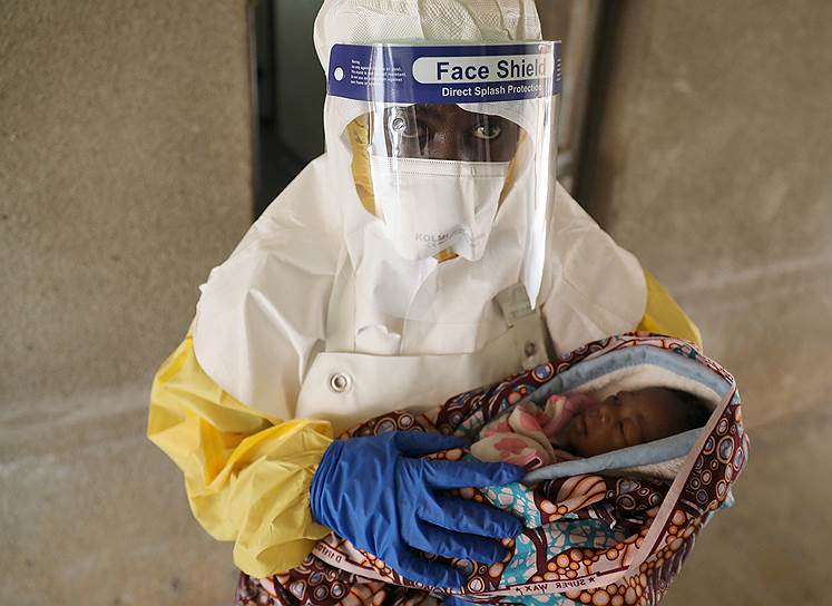 Бени, Демократическая Республика Конго. Медицинский работник с ребенком, у которого подозревают заражение вирусом Эбола
