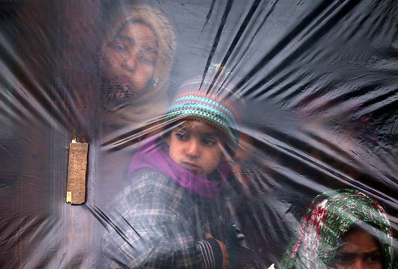 Пулвама, Индия. Ребенок смотрит из окна, сделанного из полиэтиленовой пленки 