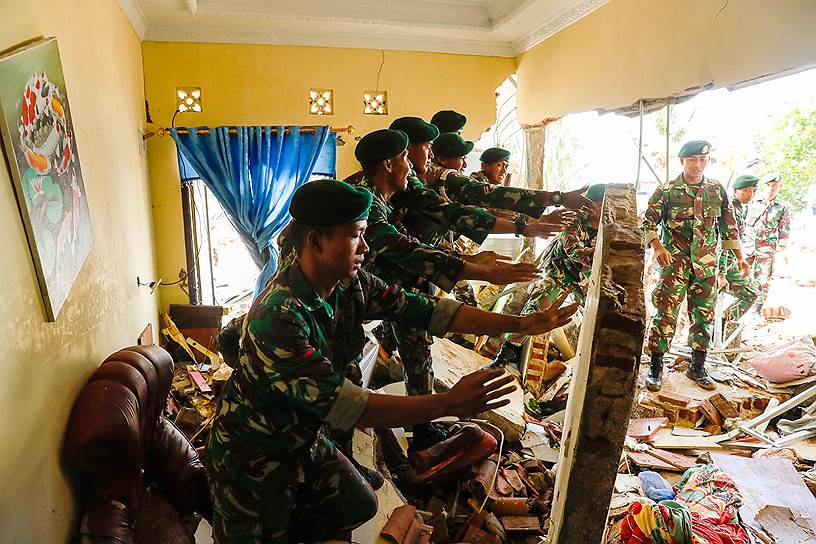 Солдаты ищут тела погибших под обрушившейся стеной в пляжном отеле, который пострадал от цунами